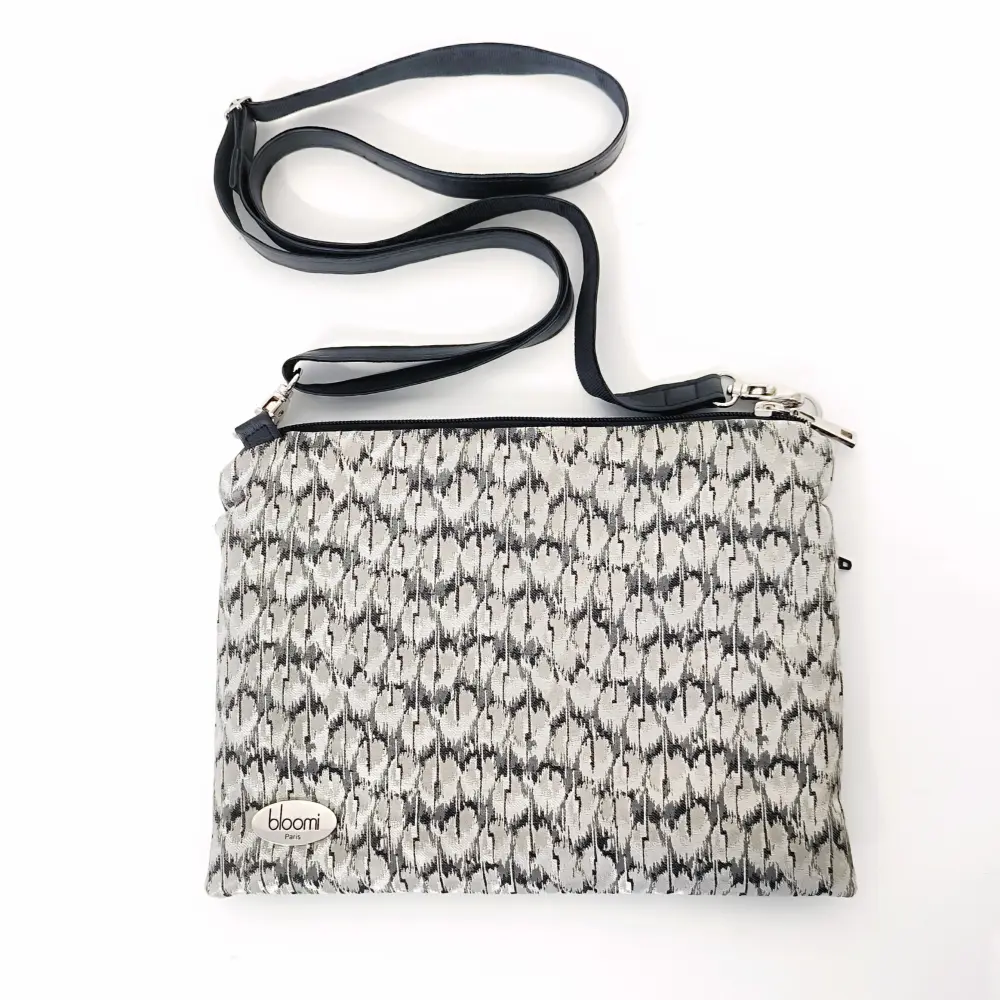 https://www.bloomi.fr/wp-content/uploads/2023/11/pochette-bandouliere-ipad-mini-cuir-vegan-noir-textile-noir-blanc-3.webp